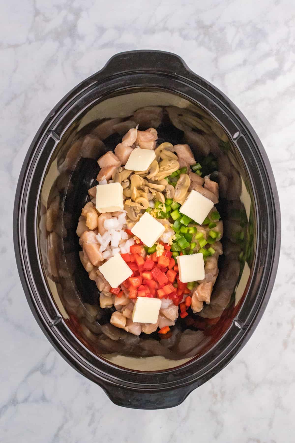 A Slow Cooker filled with vegetables and chicken a la King.